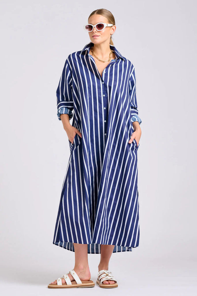 Woman wearing Shirty Luna  long blue and white striped dress on a light gray background